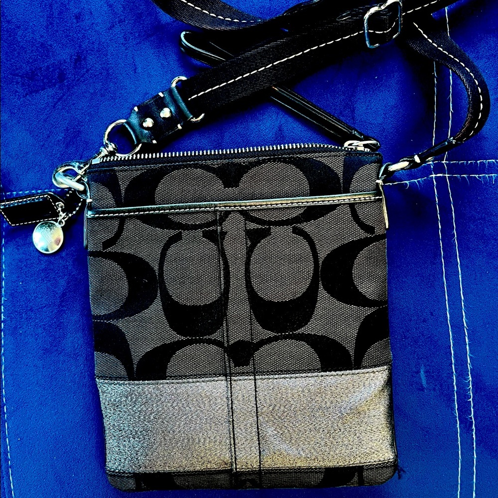 Black signature chambray and smooth leather. Crossbody and inside pocket.